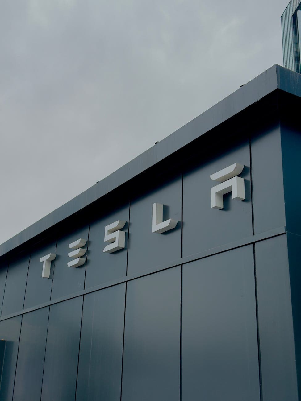Modern building facade with the Tesla wordmark on the side.