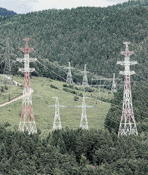 Lattice transmission towers and overhead lines crossing a forested hillside, with a blue map pin marking a customer site.